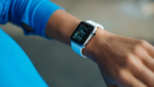 person wearing white silicone strap black smartwatch